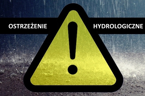 żółty trójkąt ostrzegawczy z czarnym wykrzyknikiem pośrodku na tle opadów i napisu ostrzeżenie hydrologiczne