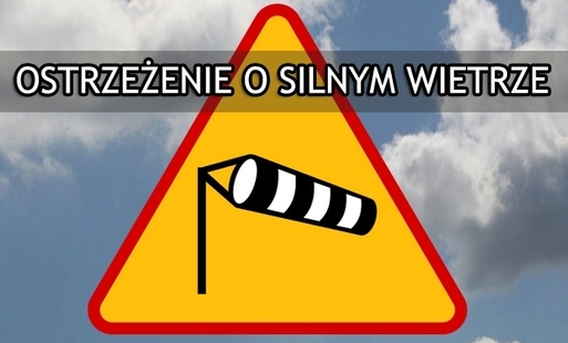 żółty trókąt ostrzegający o silnym wietrze na tle nieba z chmurami